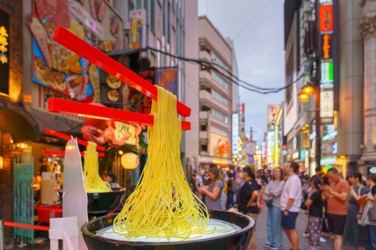 Schwebende Stäbchen über japansicher Schüssel mit Nudeln, als Deko in der japanischen Stadt Osaka