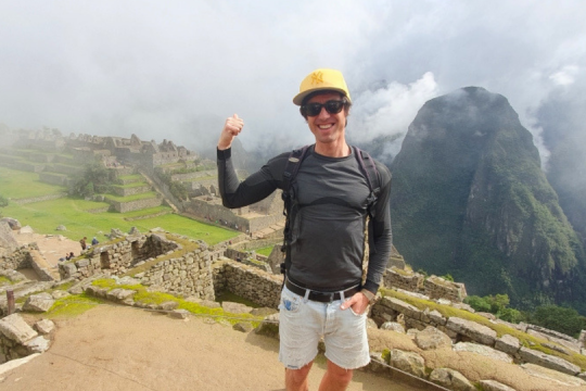 Junger Mann steht am Machu Picchu